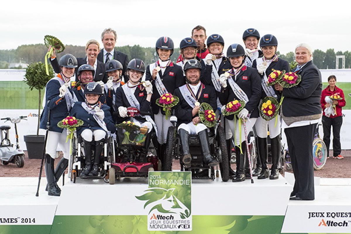 A number of jockeys standing on a podium holding flowers