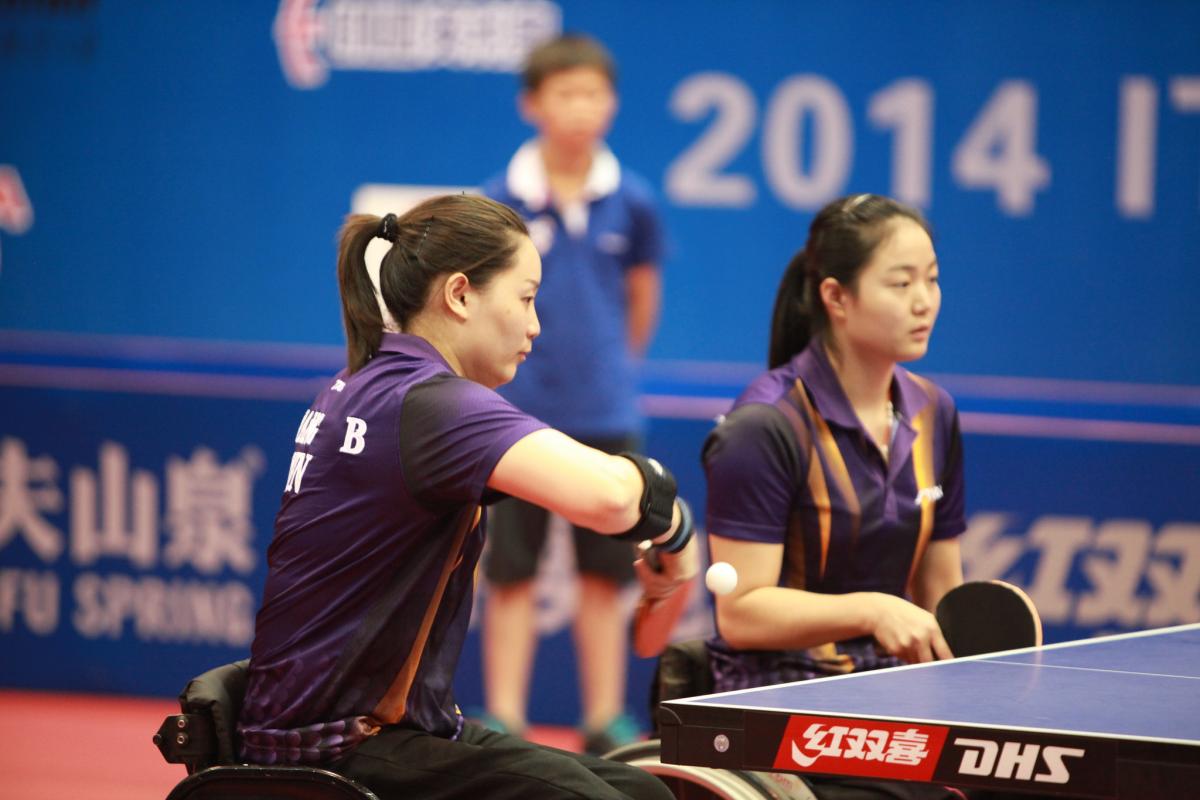 two female Chinese para table tennis players playing doubles