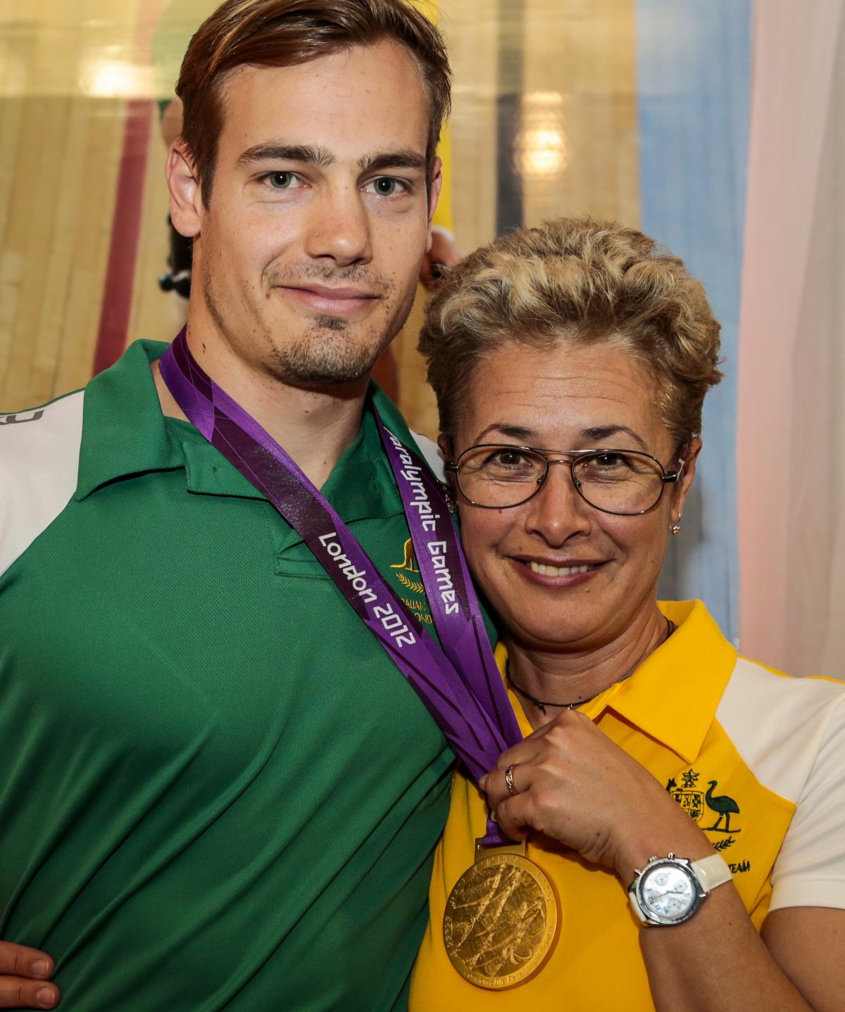 Women and man pose with a medal