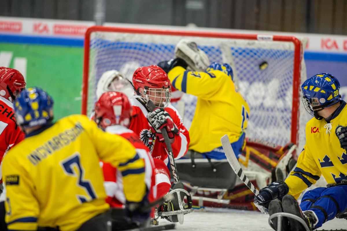 Five ice sledge hockey players on the field during a game