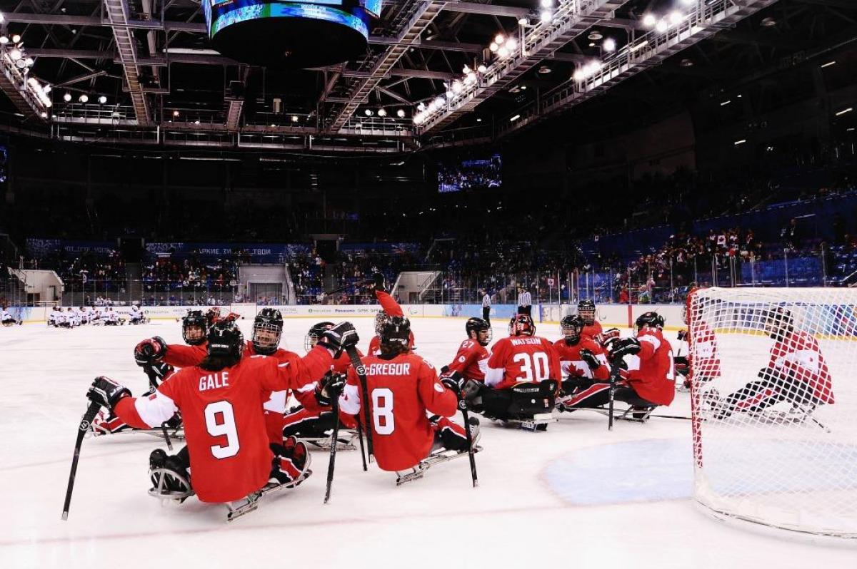 Canada players celebrate after the ice sledge hockey bronze medal game between Canada and Norway at the Shayba Arena at the 2014 Paralympic Winter Games.