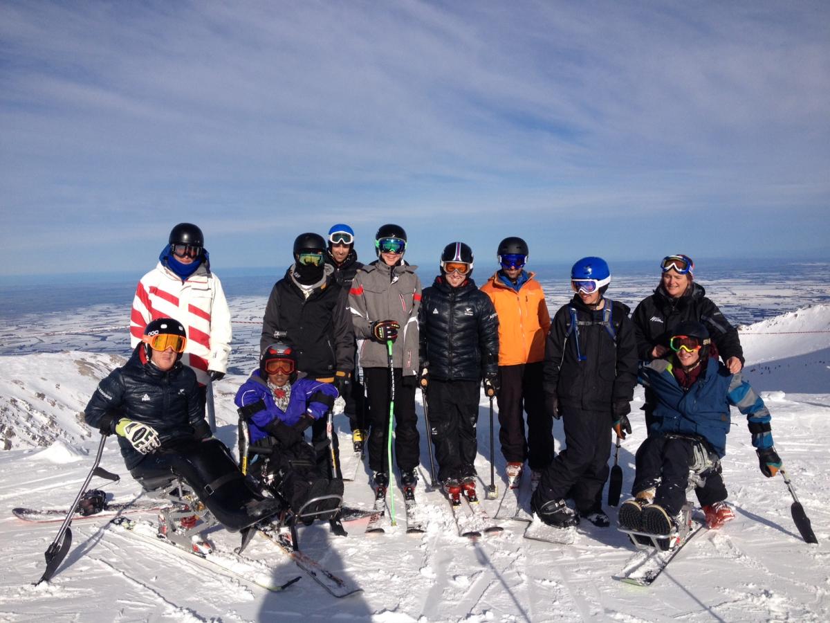 Group shot of skiers (sitting and standing) on a mountain