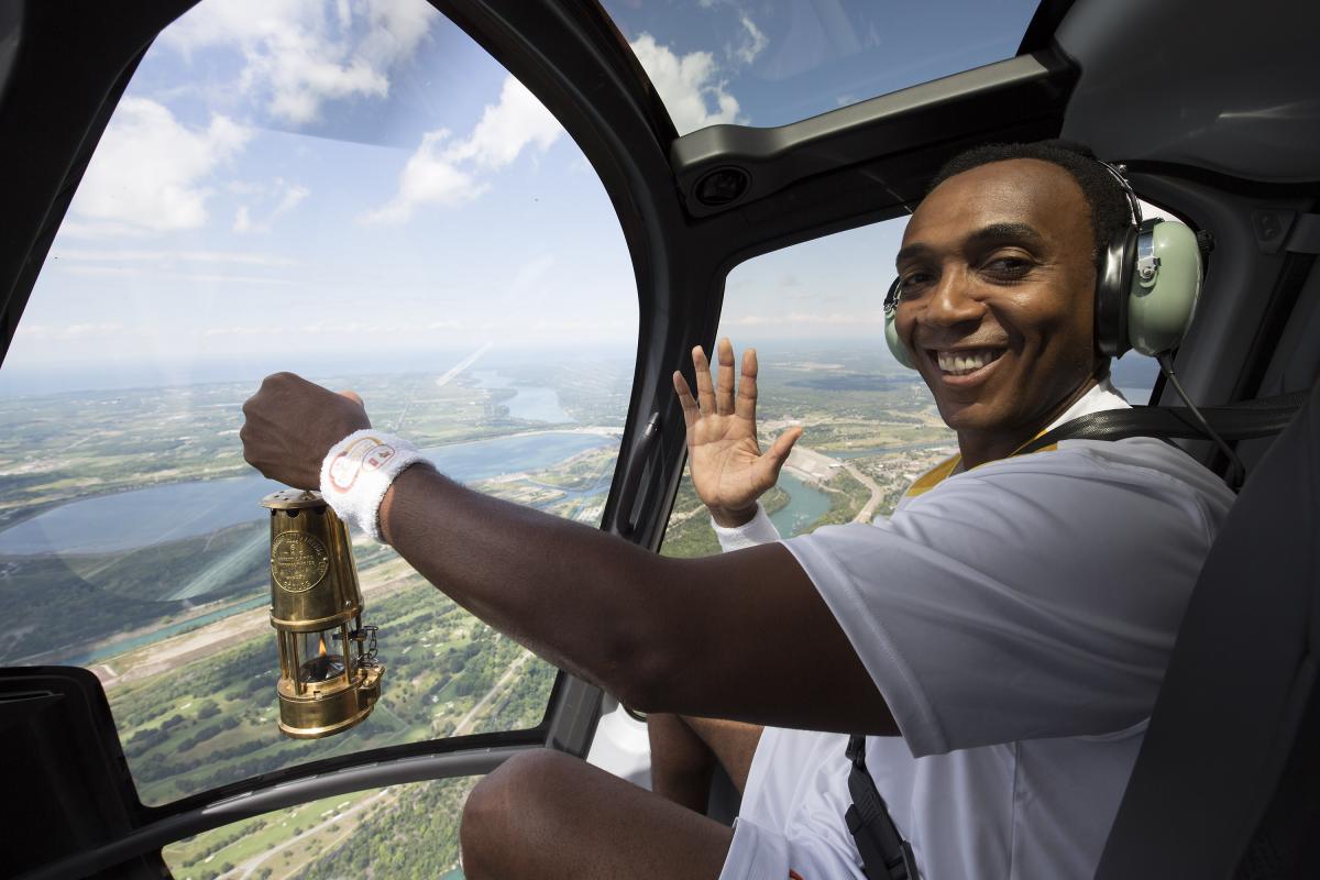 Dwight Drummond, CBC News Toronto co-host, carries the Parapan Am flame on board a helicopter in Niagara Falls, Ontario.