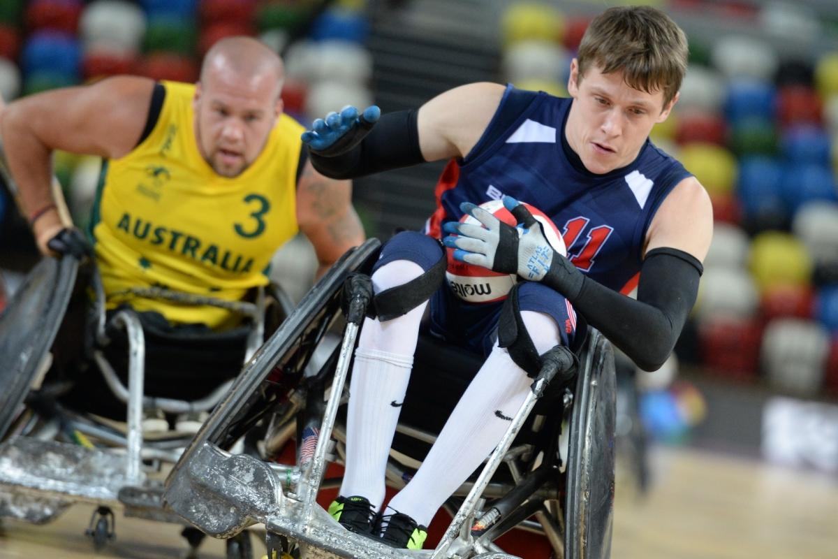 Two wheelchair rugby players fighting for the ball