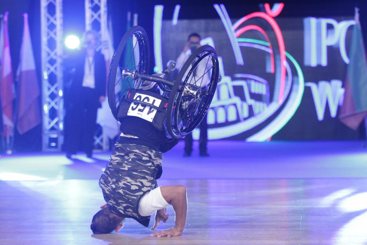 Man in wheelchair does headstand