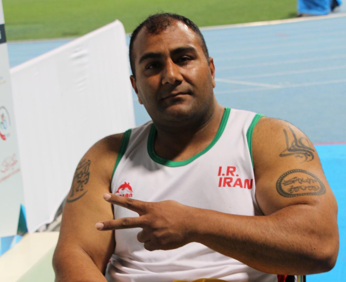 Iran's Hamed Amiri shows the "V" for victory sign with his fingers