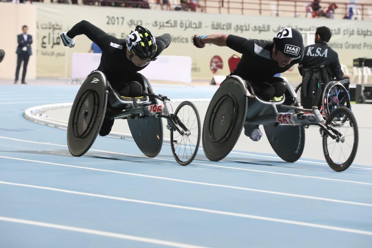 two male wheelchair racers come round the final bend