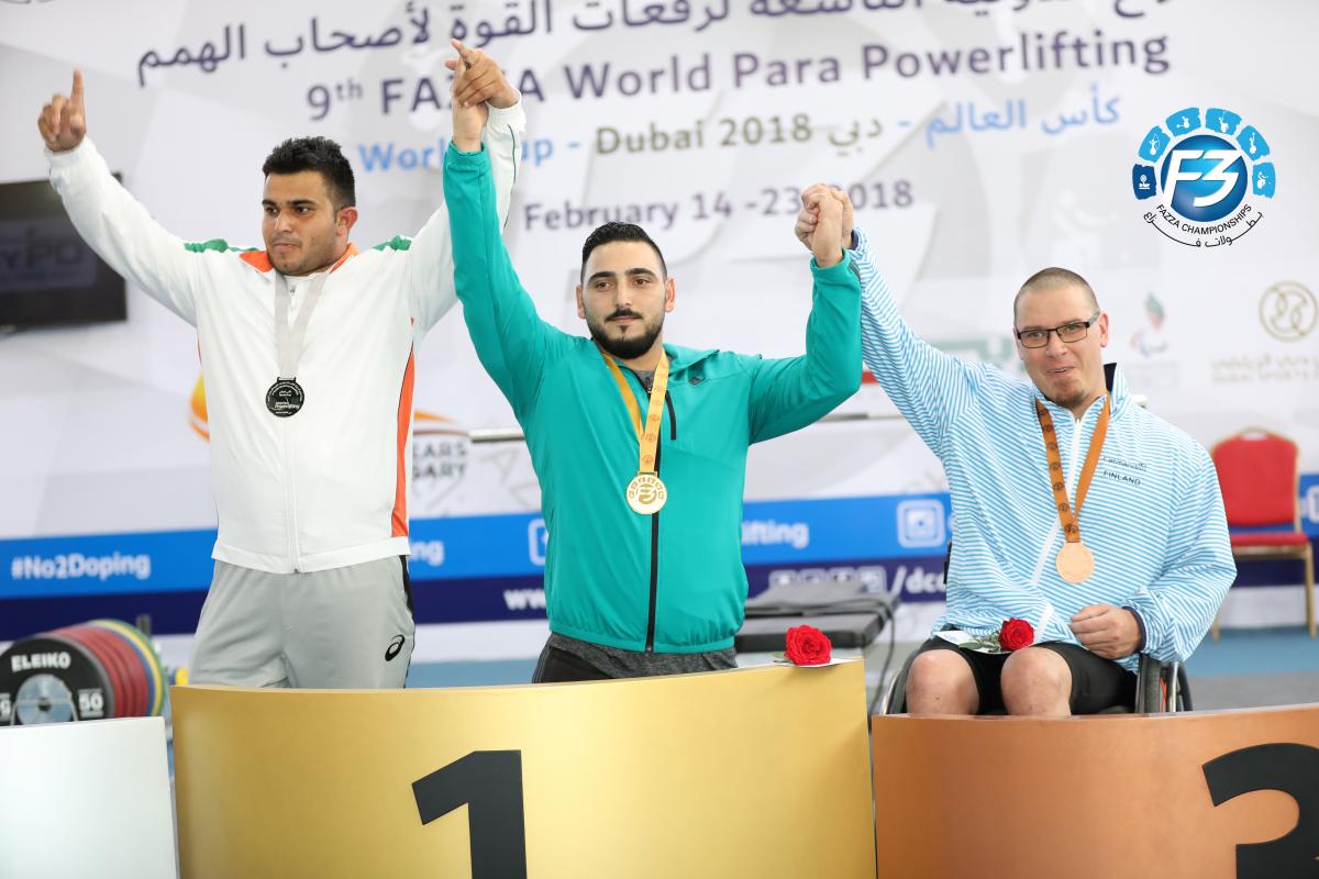 three male powerlifters on the podium