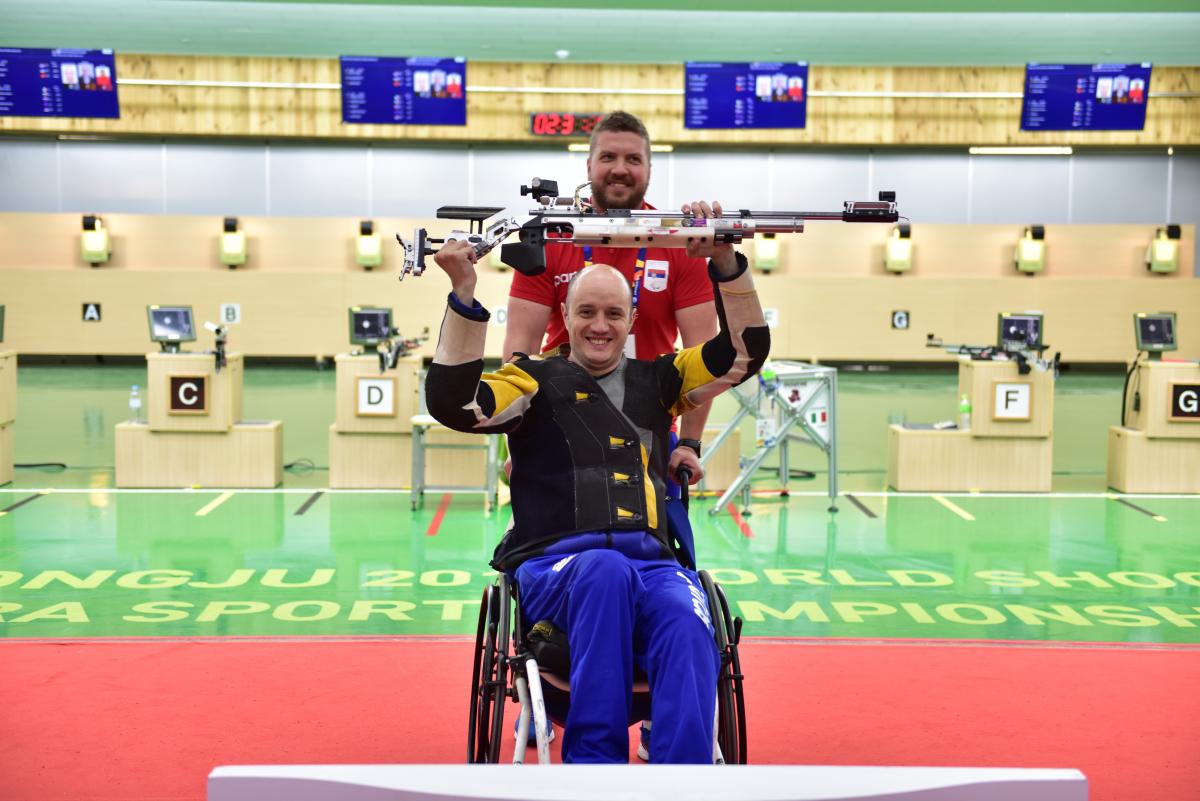 a male Para shooter and his coach celebrate 