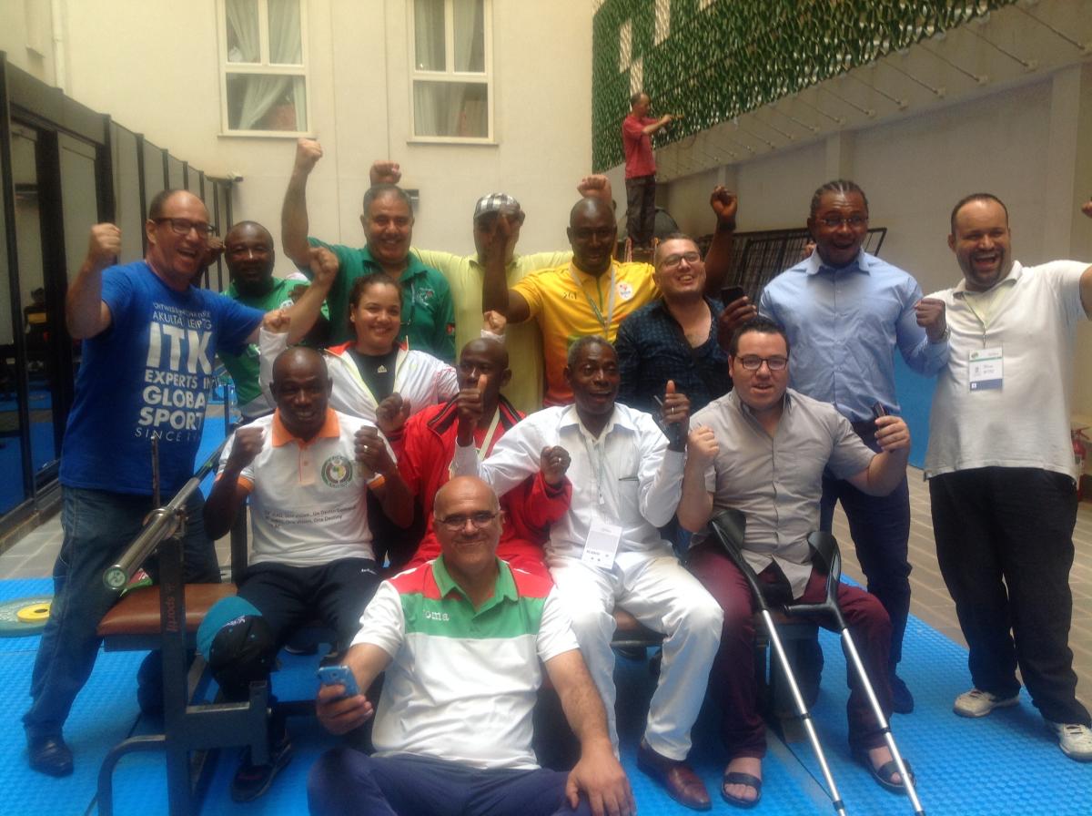 a group of African powerlifting officials smile for the camera