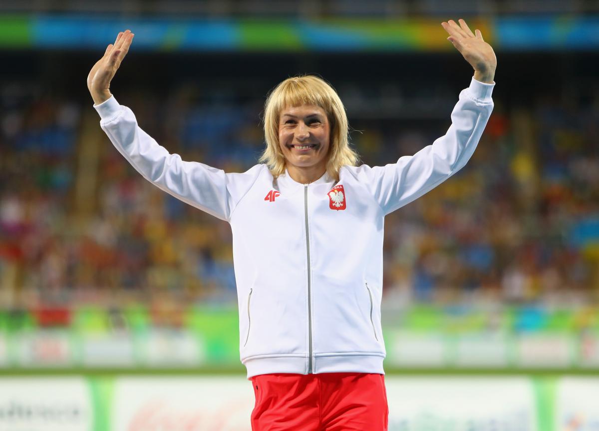 female Para sprinter Barbara Niewiedzial raises her arms on the podium