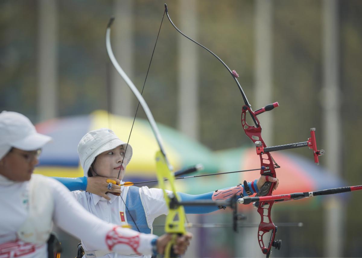 Chinese female archer pulls back her bow ready to shoot her arrow