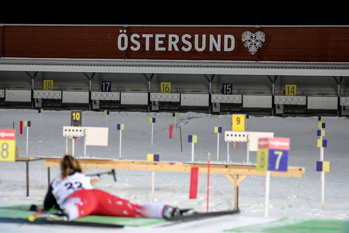 A female Para biathlete laying on the ground to shoot on the target