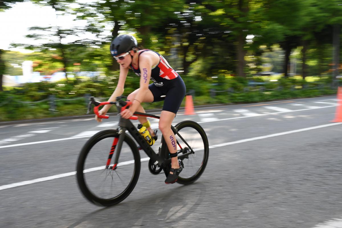 Female British triathlete with arm impairment rides her bike