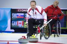 A picture of 2 mens in wheelchairs playing curling
