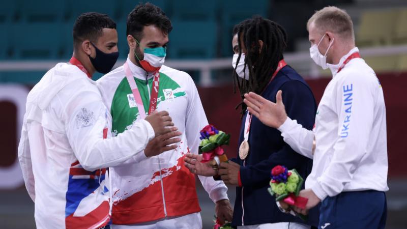 four Para judokas chatting with their medals 