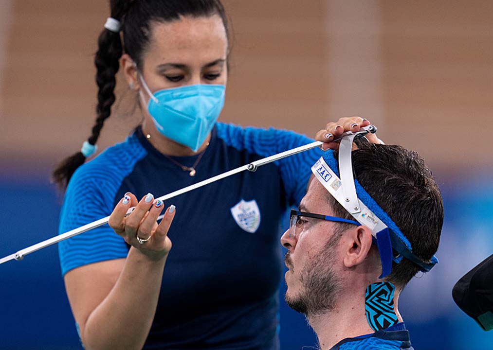 Grigorios Polychronidis's assistant and wife Katarina adjusts his pointer