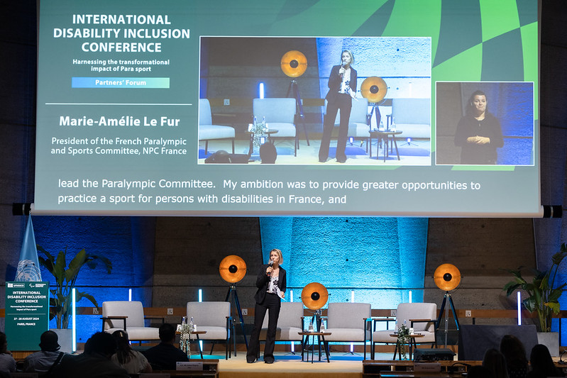 Marie-Amelie Le Fur speaking to a room of people on a stage