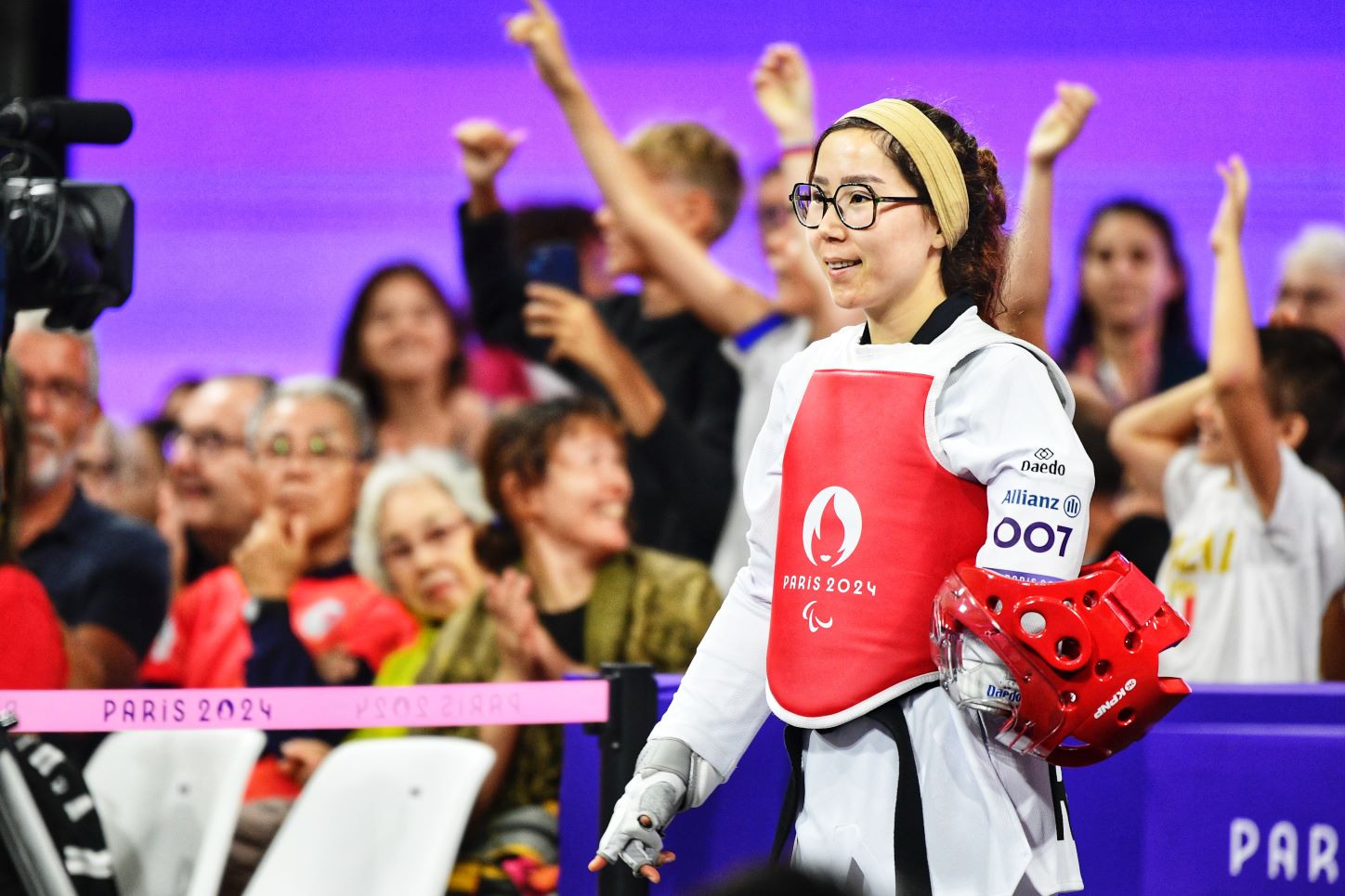 Zakia Khudadadi, a female Para taekwondo athlete, stands in front of spectators