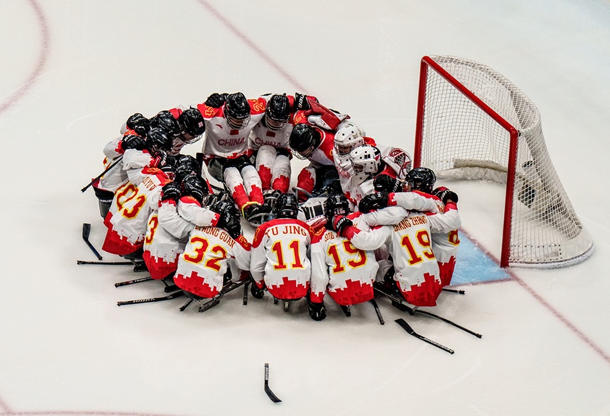 The para ice hockey team from China form a circle