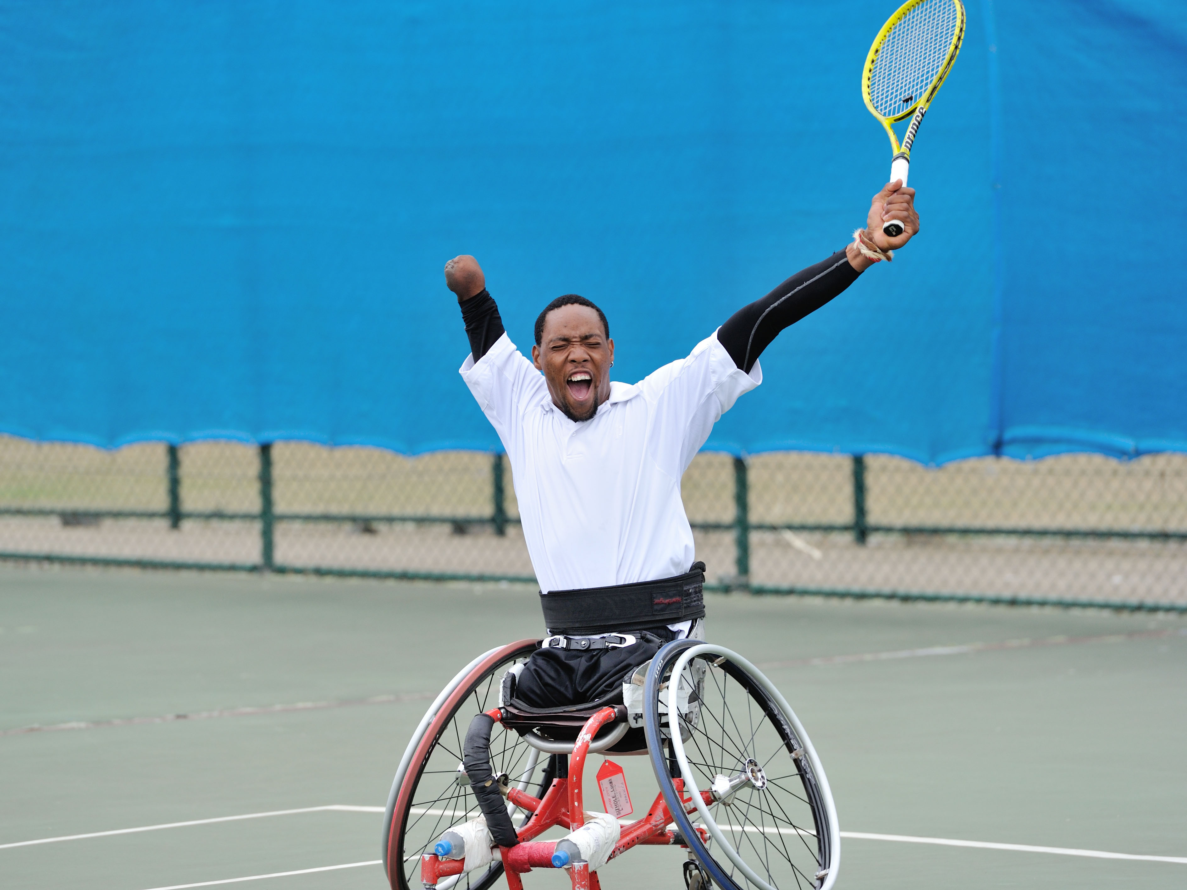 Adaptive tennis player smiling after a long rally