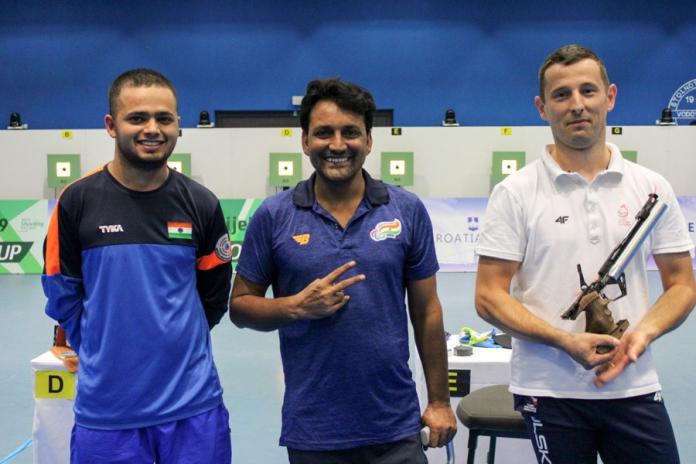 Three male pistol shooters pose for a photo