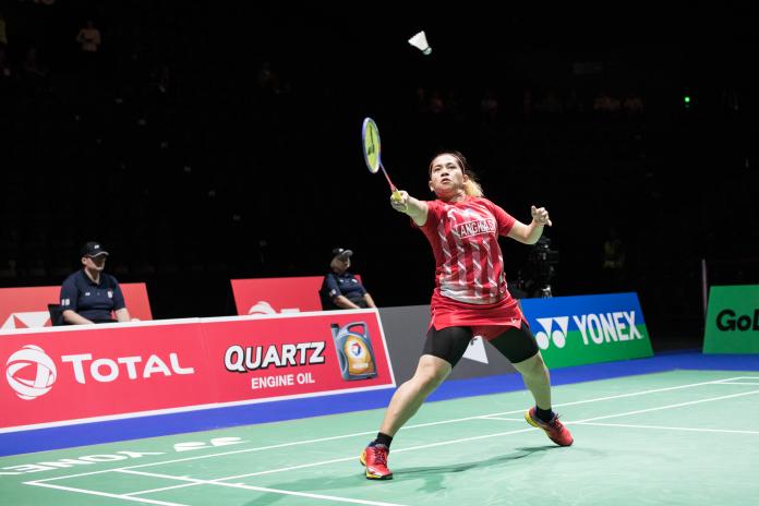 Indonesia female badminton player lunges for the shuttle