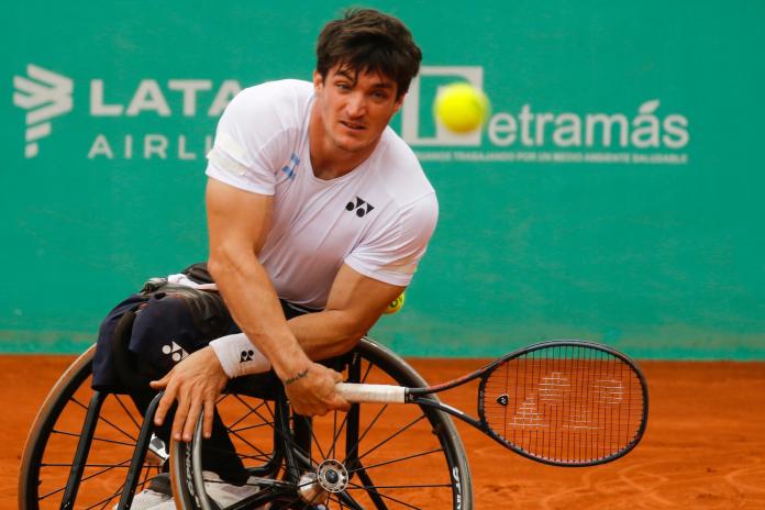 a male wheelchair tennis player plays a forehand