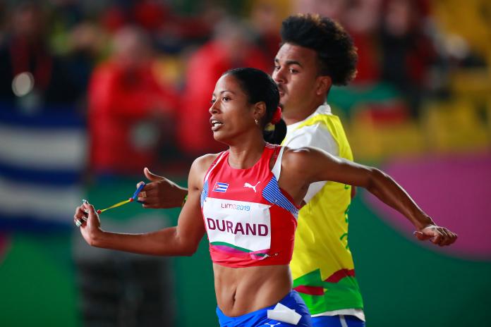 a female vision impaired runner and her guide running on the track