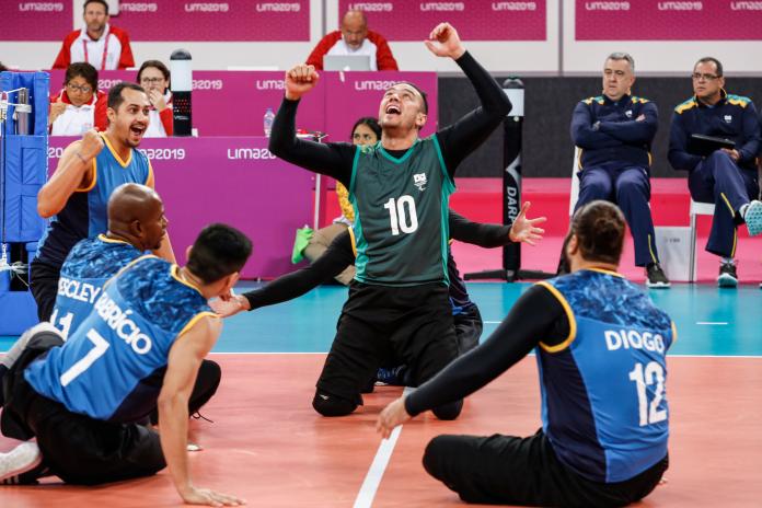 Sitting volleyball players celebrate on the court