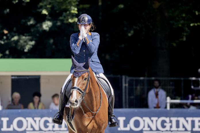 Woman on her horse claps hands in amazement