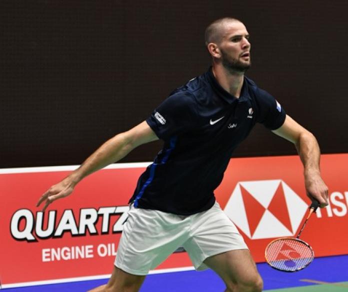 French male badminton player about to lunge for the birdie