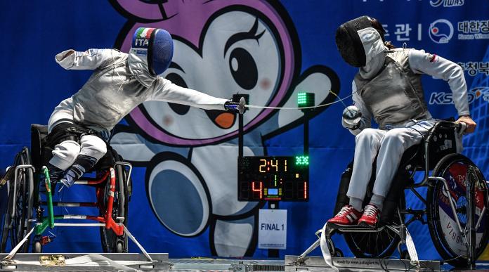 A wheelchair fencer lands a blow on her opponent