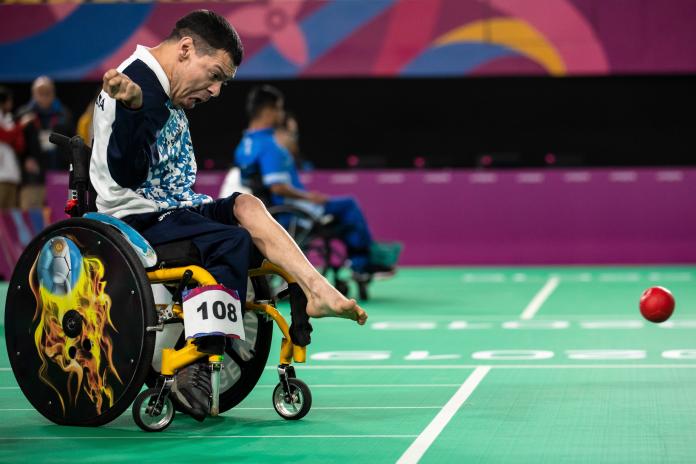 Argentinian boccia player throws the ball with his foot