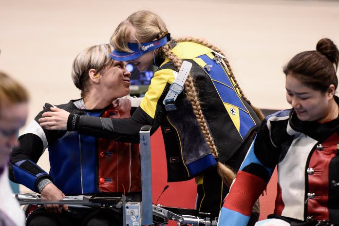 Two female shooters hugging