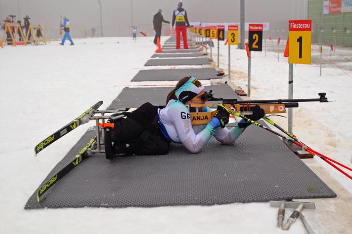 Female sit-skier focuses her rifle in biathlon