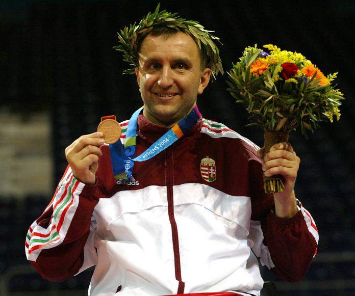 Man smiling with medal and flowers
