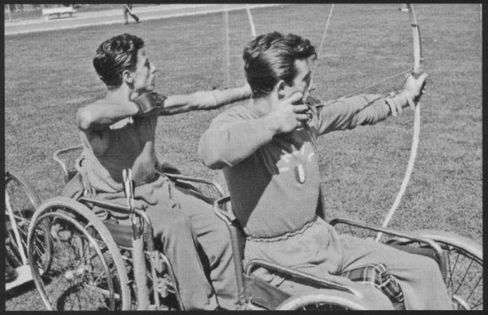 Two male archers in wheelchairs competing in archery - black and white photo from 1960