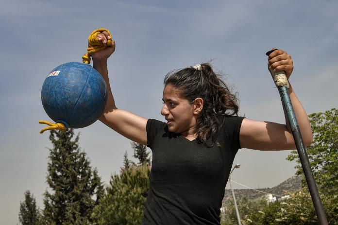 Para athlete staring at a ball which she is holding to her right