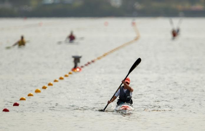 Female para canoe athlete training on water