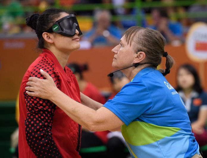 Referee checks eye shades of goalball player