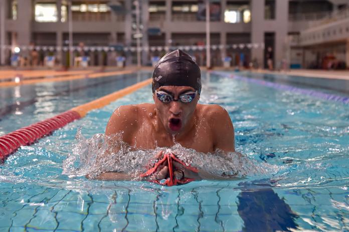 Swimmer Ibrahim Al Hussein swimming breaststroke to the camera