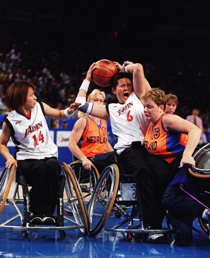 Japanese player holds the ball while surrounded by Japanese and Dutch players