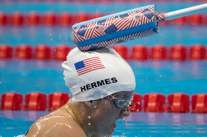 Female vision impaired swimmer is tapped in the head to make her turn