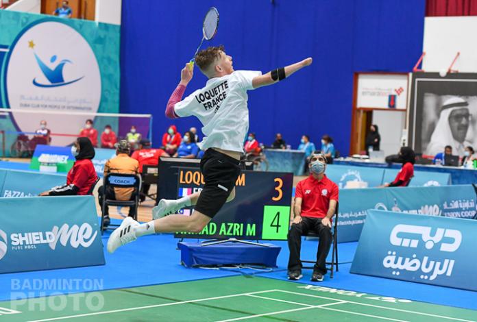 French male badminton player with missing right forearm jumps to hit the shuttle