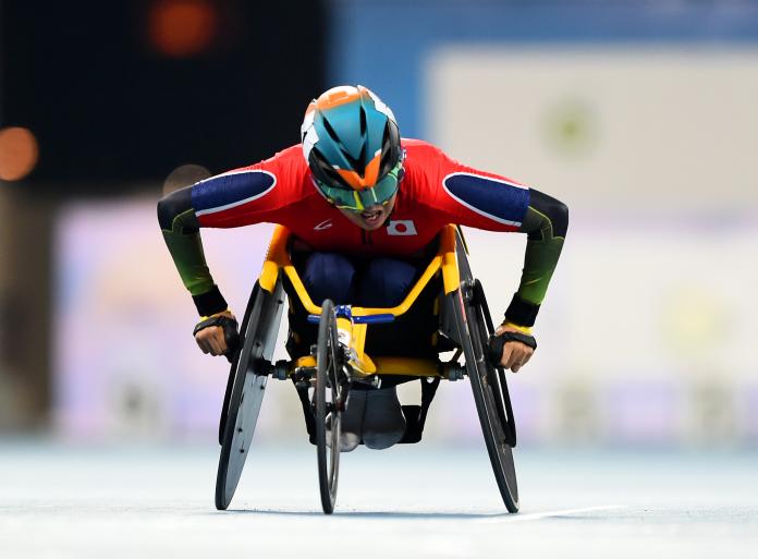 Japanese wheelchair racer pushing forward during a race