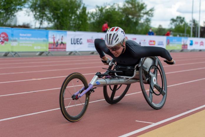 A woman in a racing wheelchair during a Para athletics race