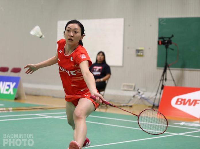 Japanese female badminton payer lunges for the shuttle