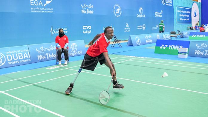 African man with right leg impairment reaches for the shuttle