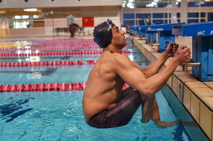 Male swimmer getting set on the blocks